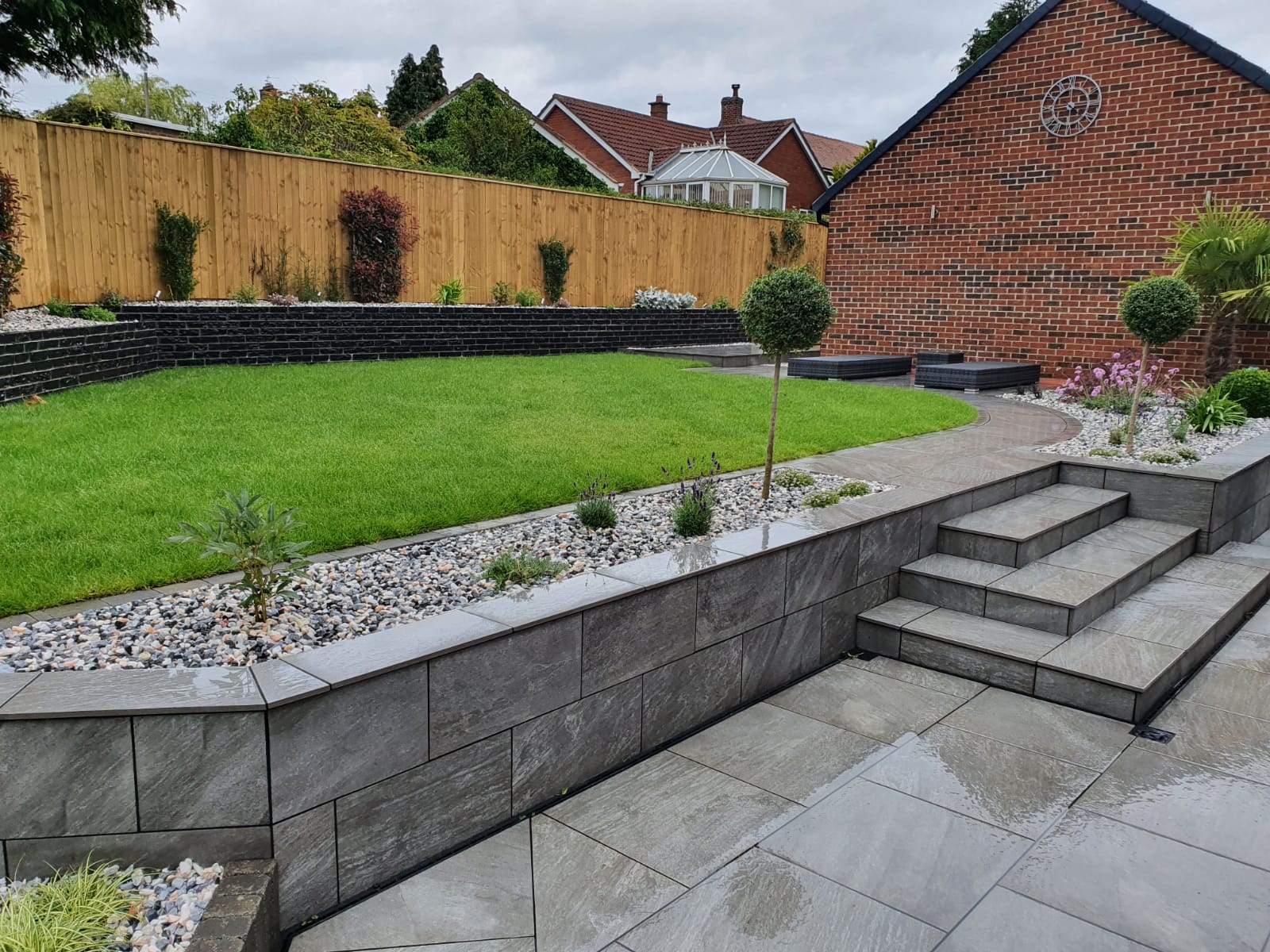 Raised grass garden with grey porcelain patios